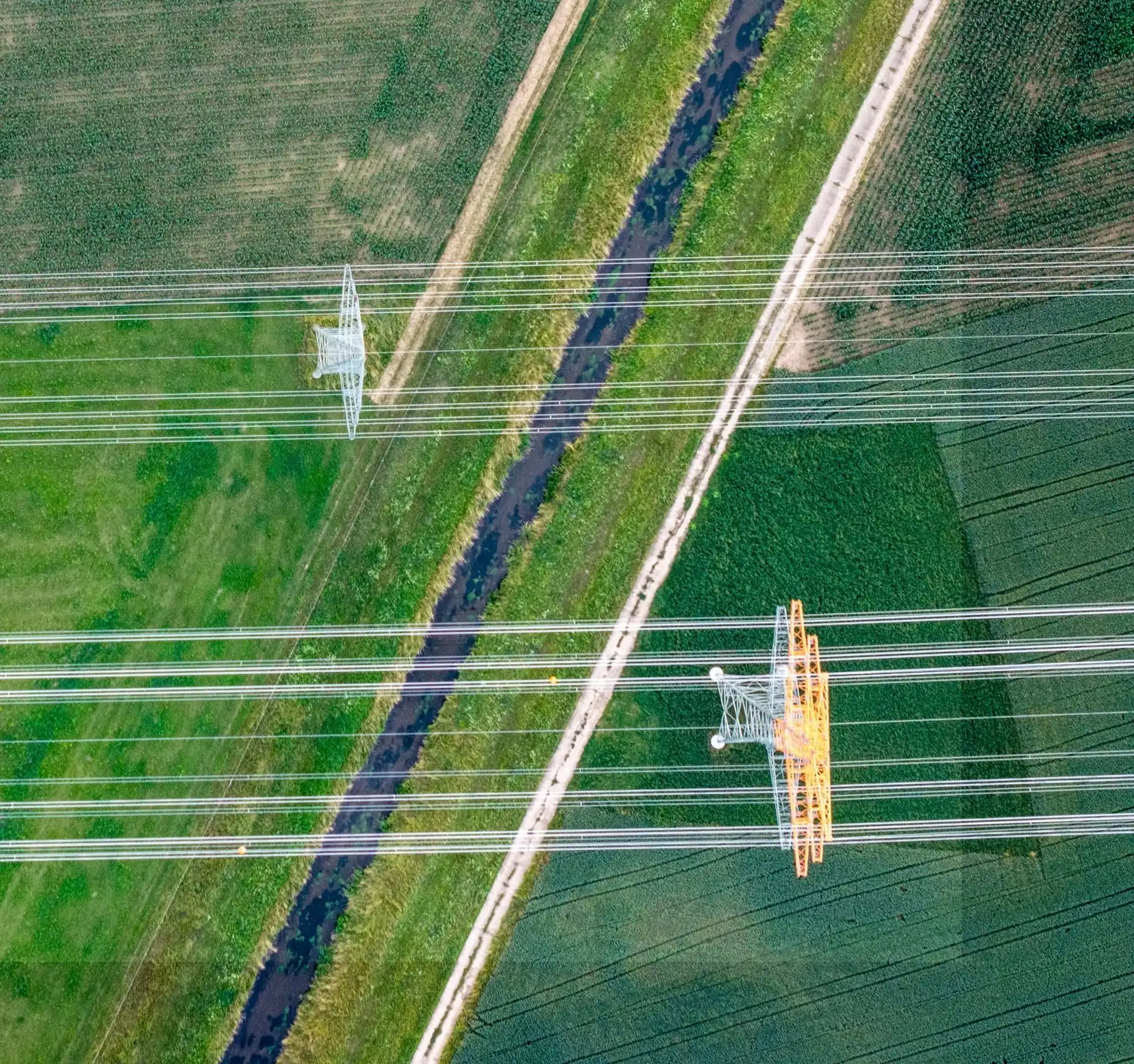 Aerial view of power lines crossing fields